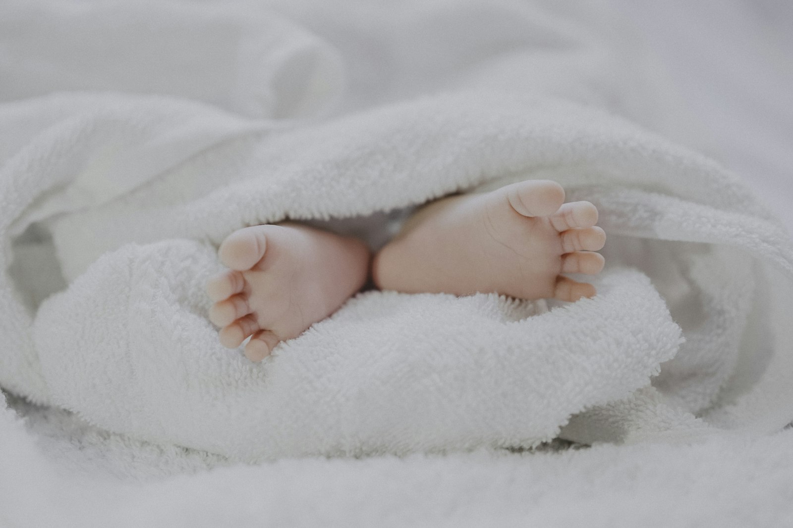 Close-up of a newborn wrapped in a hospital blanket